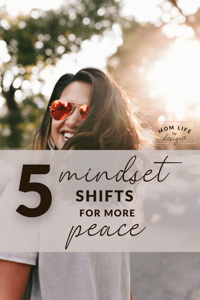 a woman in sunglasses smiles as she walks through sunlit trees with text overlay of the words " 5 mindset shifts for more peace"